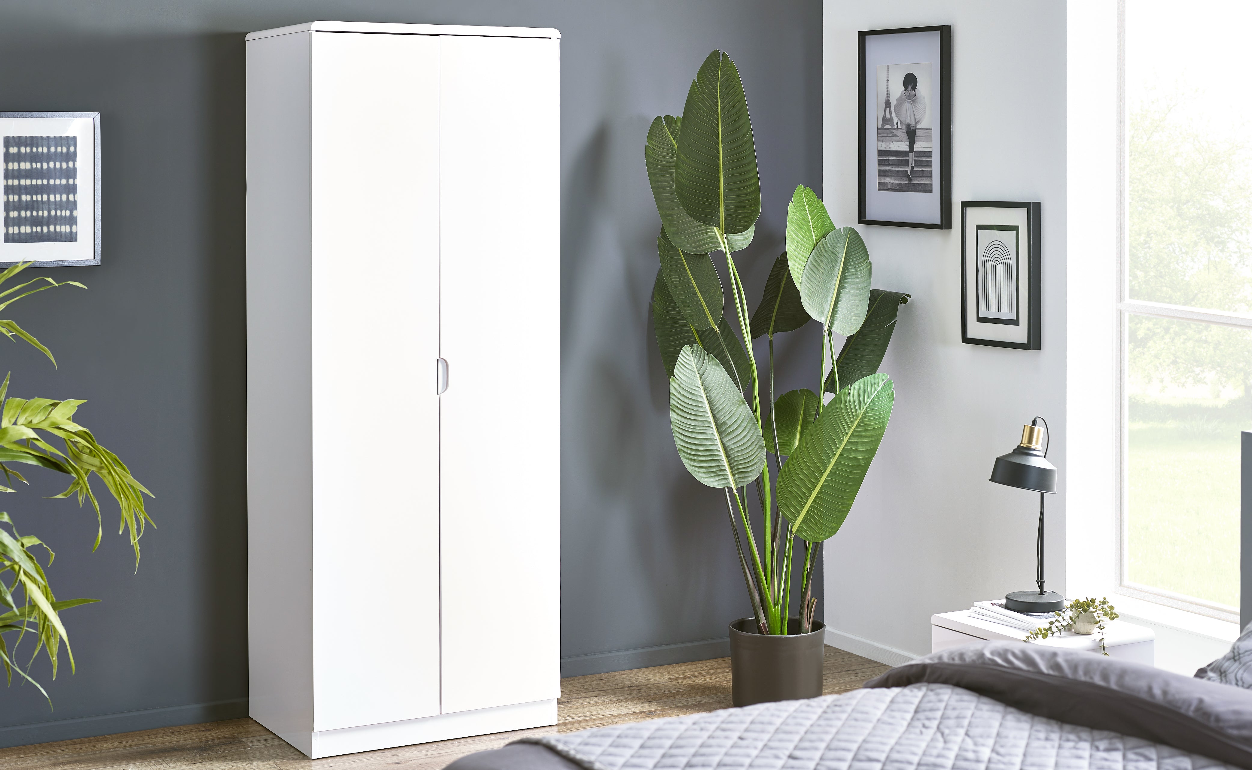 White wardrobe in a bedroom with plants and decor