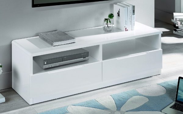 White high-gloss TV stand with electronic devices in a modern living room.