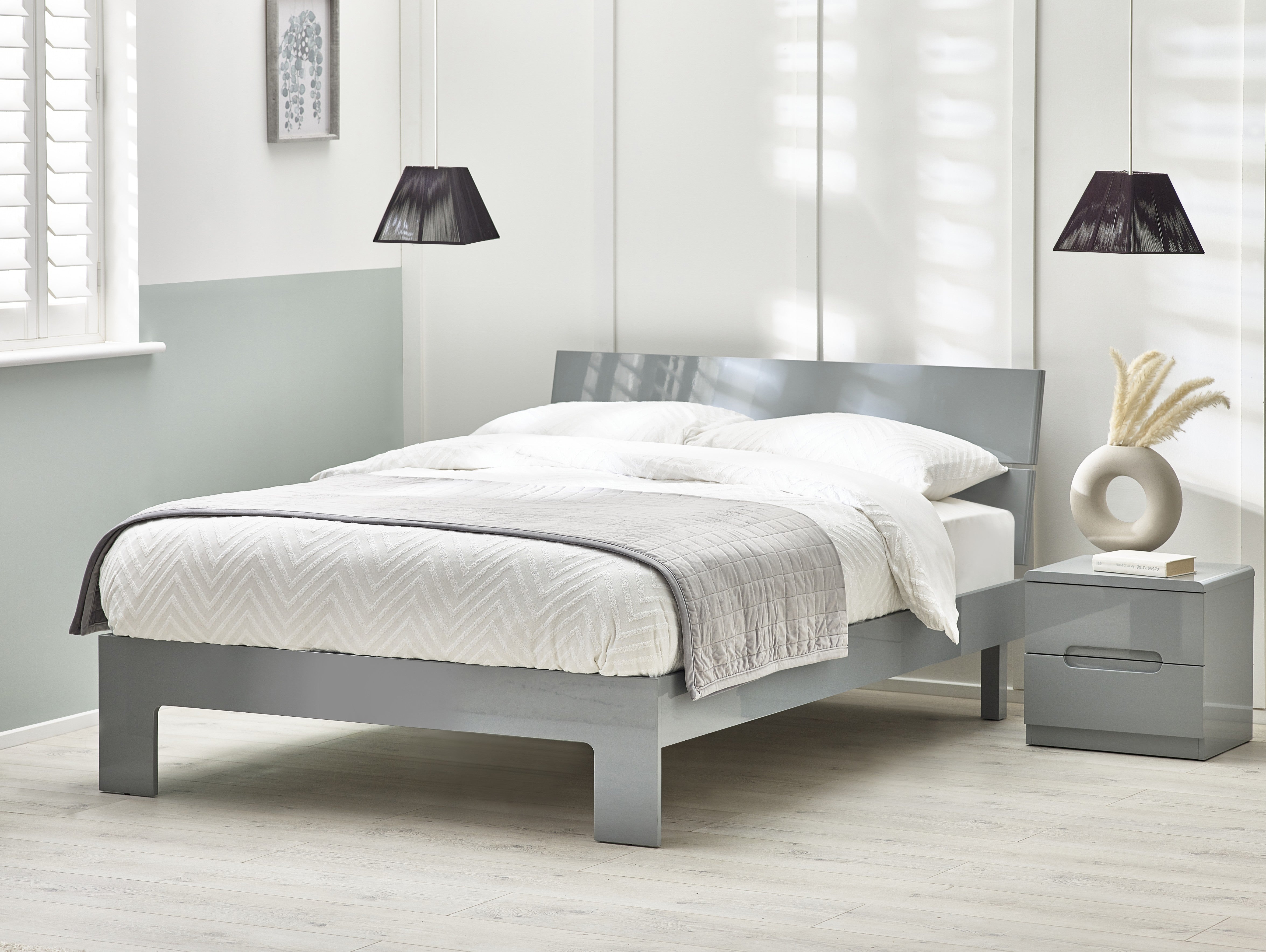 Gray bed frame with white bedding in a bedroom setting.