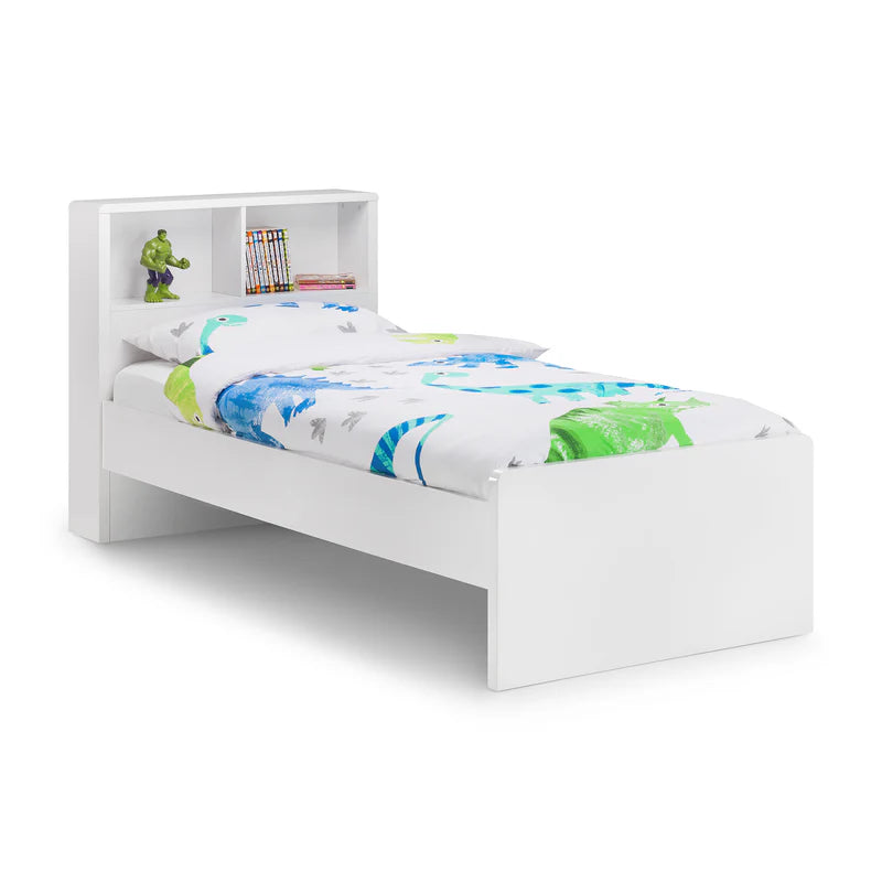 White children's bed with colorful bedding and bookshelves on a white background