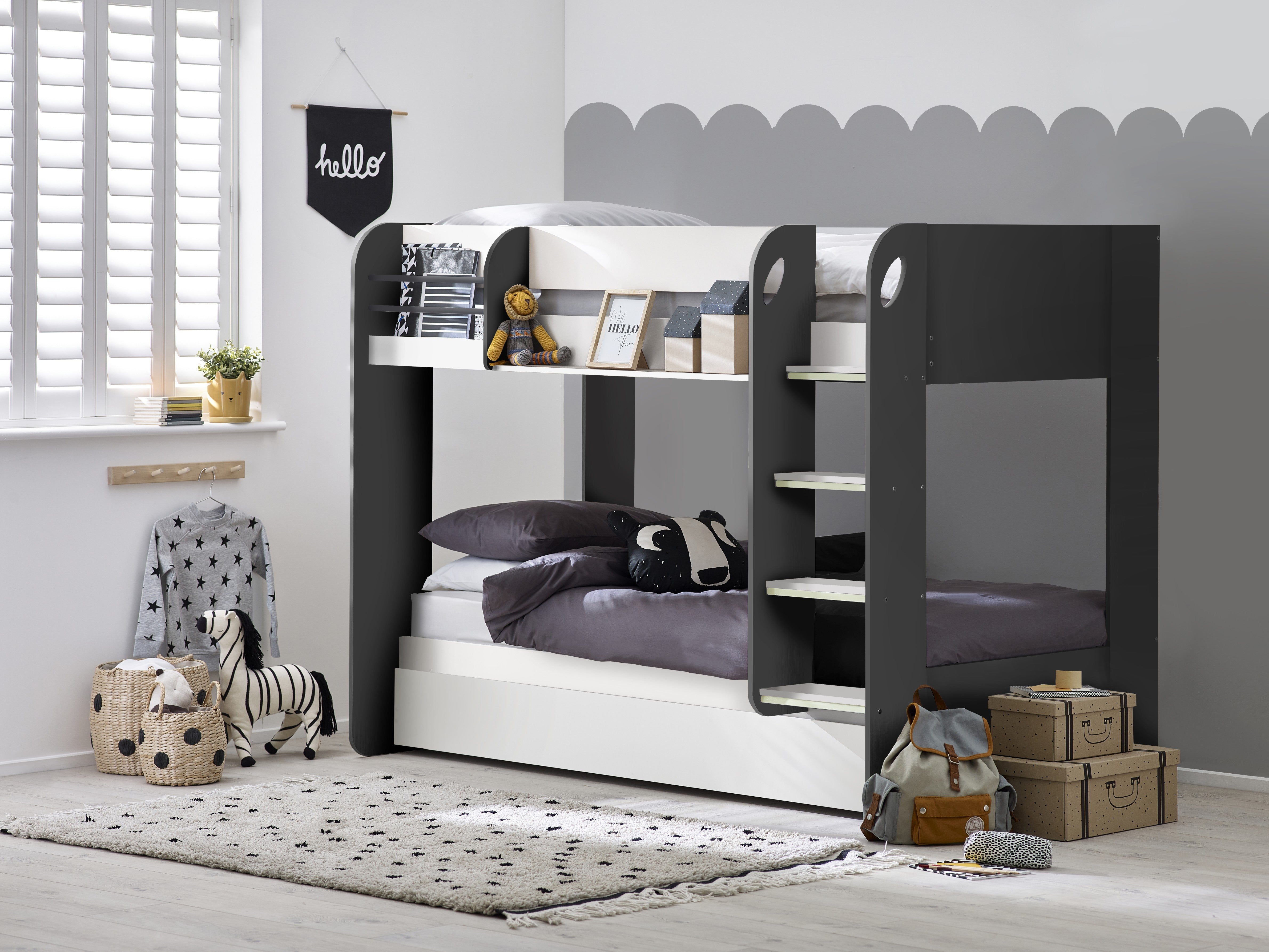 Bunk bed in a room with toys and boxes on a gray wall background