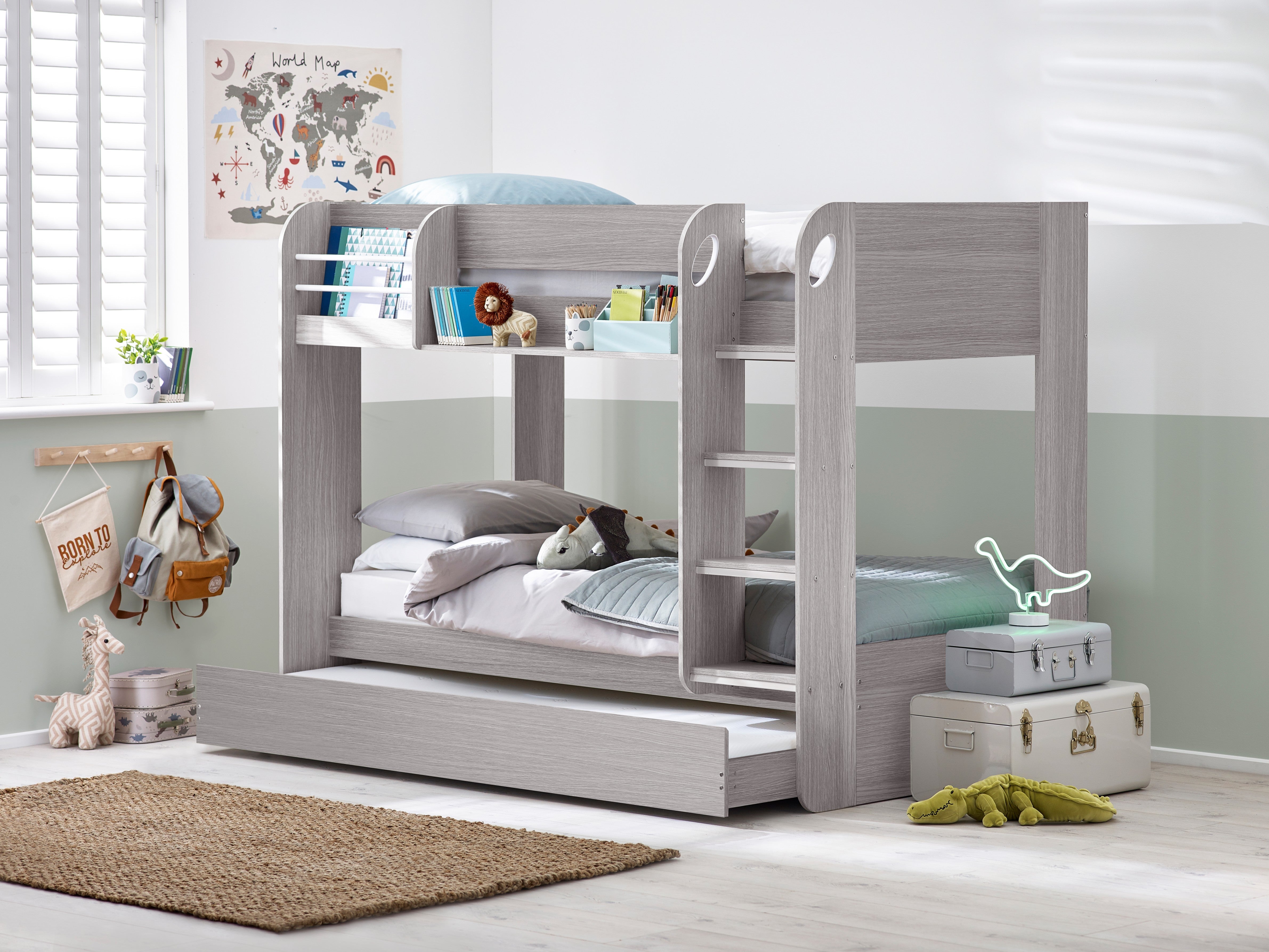 Gray bunk bed with pull-out trundle in a room with toys and decor.