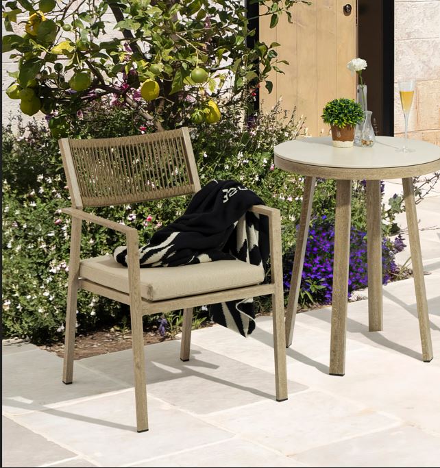 Outdoor furniture set with a chair and table in a garden setting.