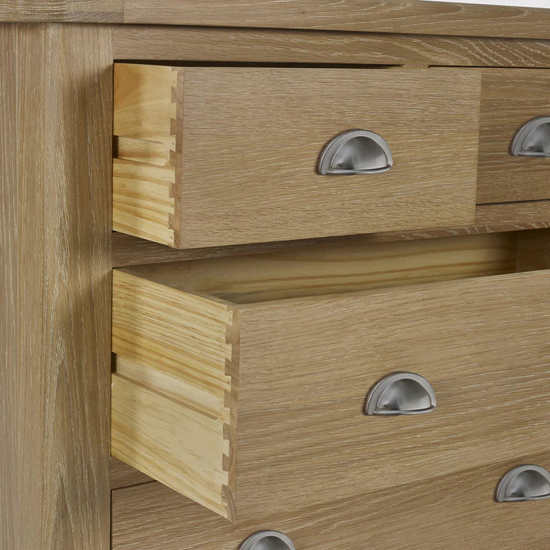 Close-up of a wooden dresser with drawers and metallic handles.