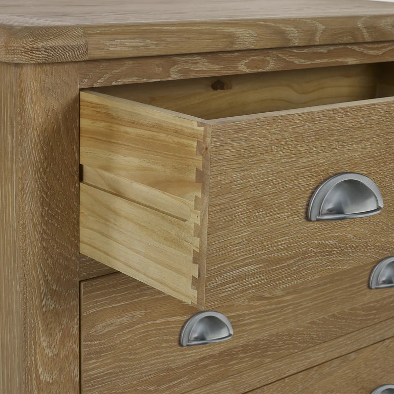 Close-up of a wooden drawer with metal handles on a piece of furniture.