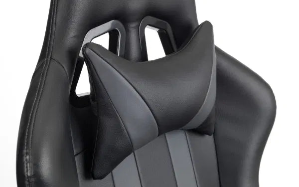 Black gaming chair with headrest and neck pillow on a white background