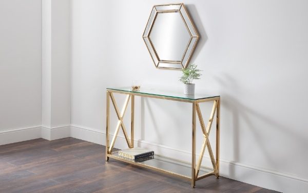 Console table with glass top and gold frame against a white wall