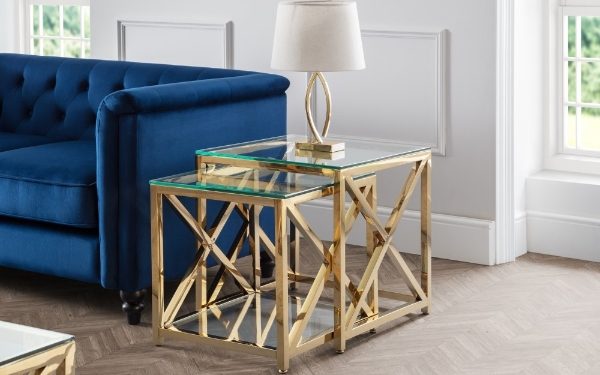 Nesting tables with gold frames and glass tops in a living room setting.