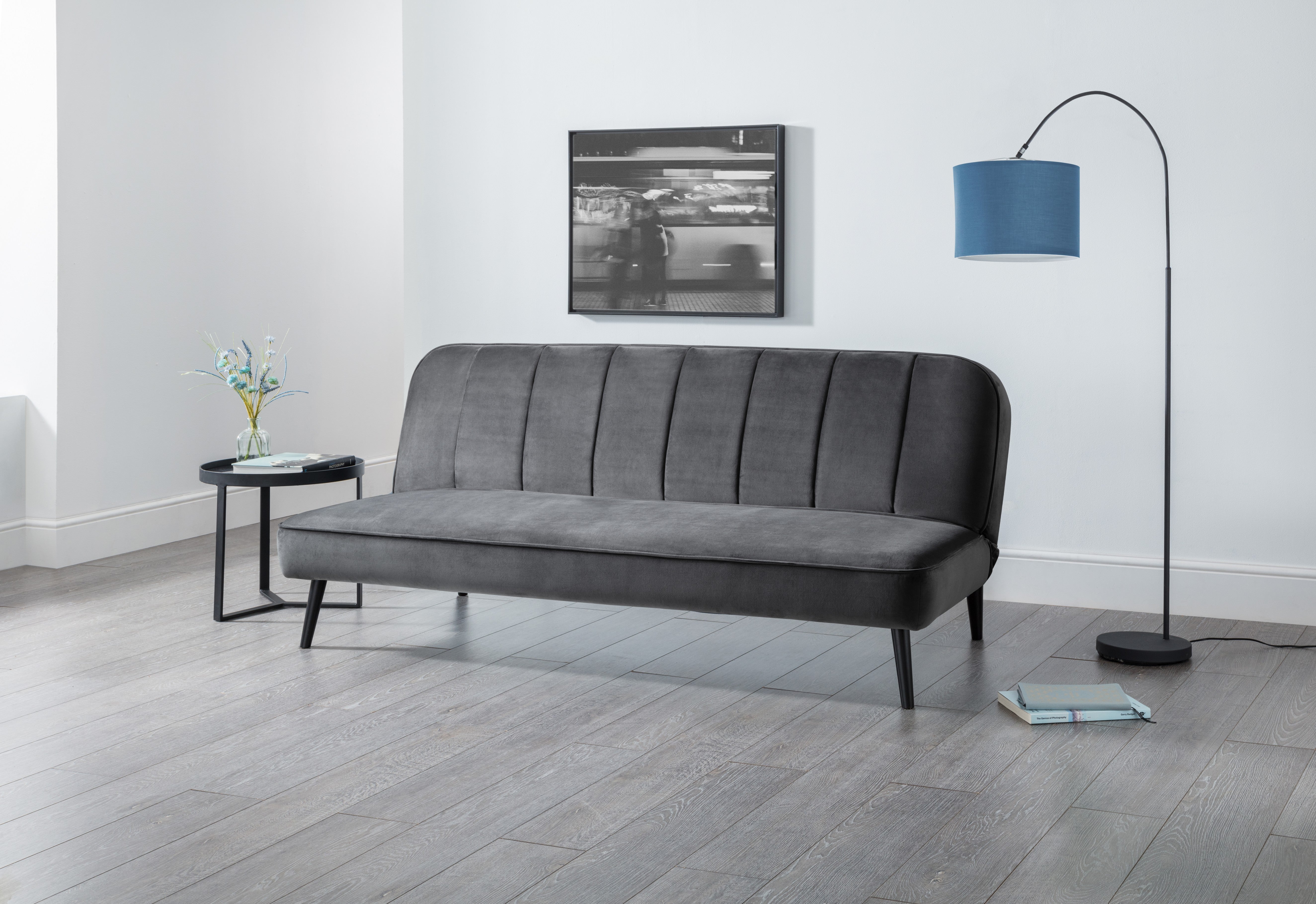 Gray sofa in a room with a lamp and small table
