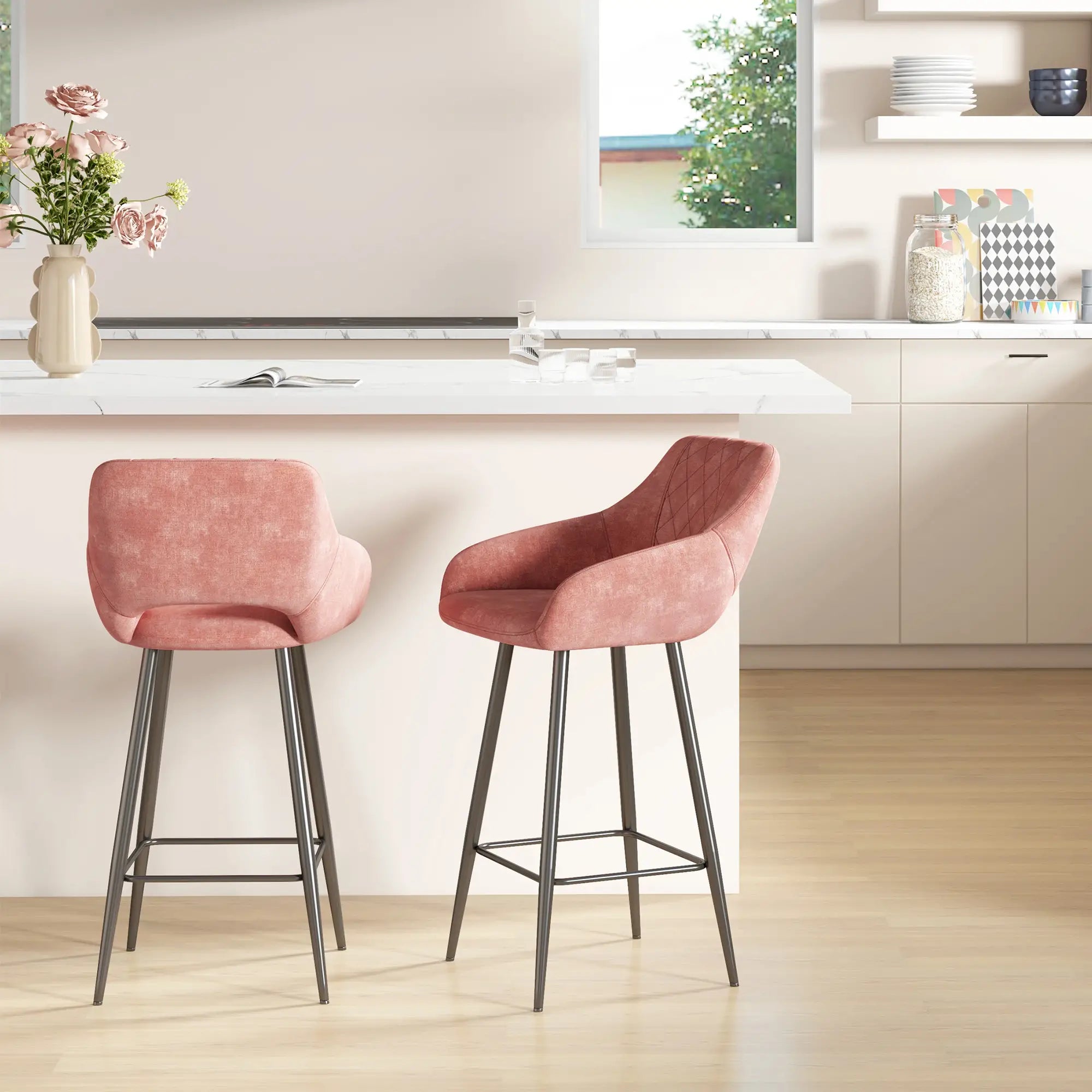 Two pink bar stools in a modern kitchen setting with a vase of flowers on the counter.