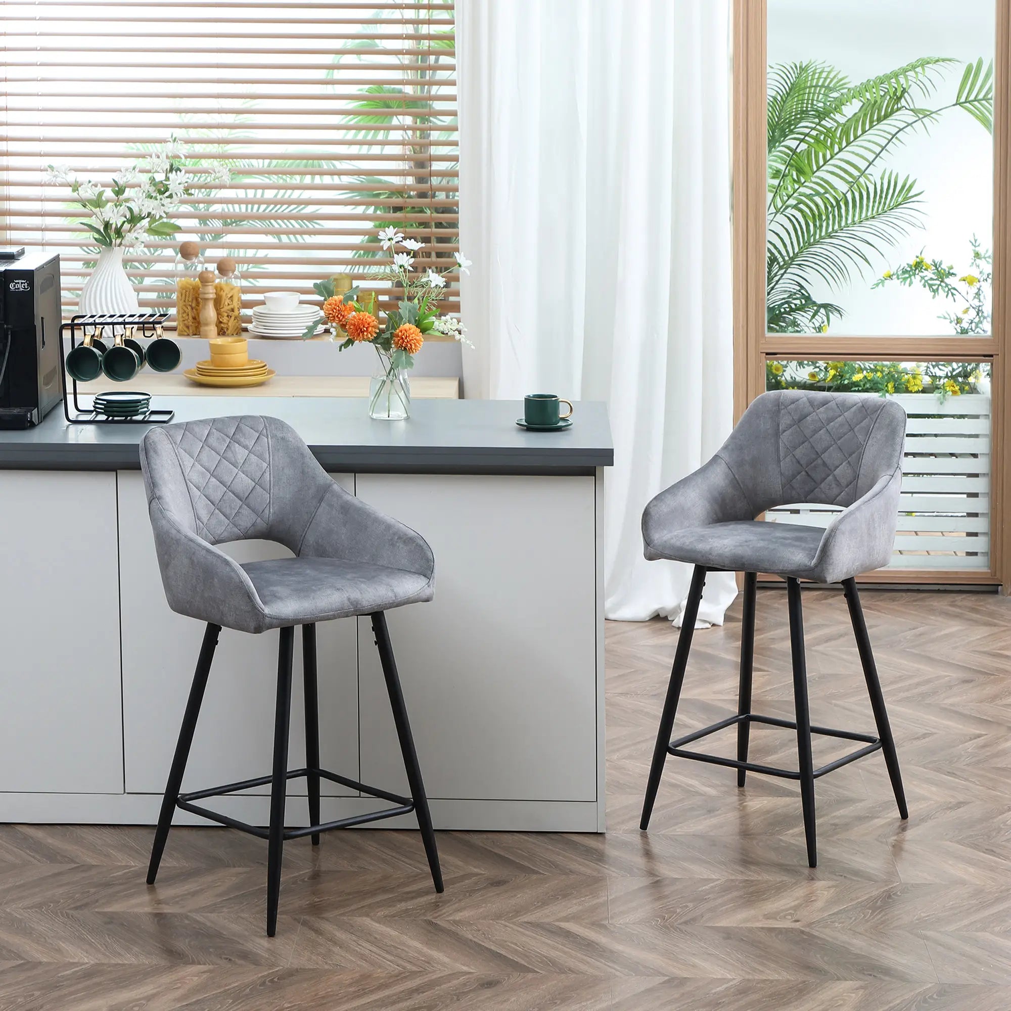 Two gray bar stools with black legs in a kitchen setting.
