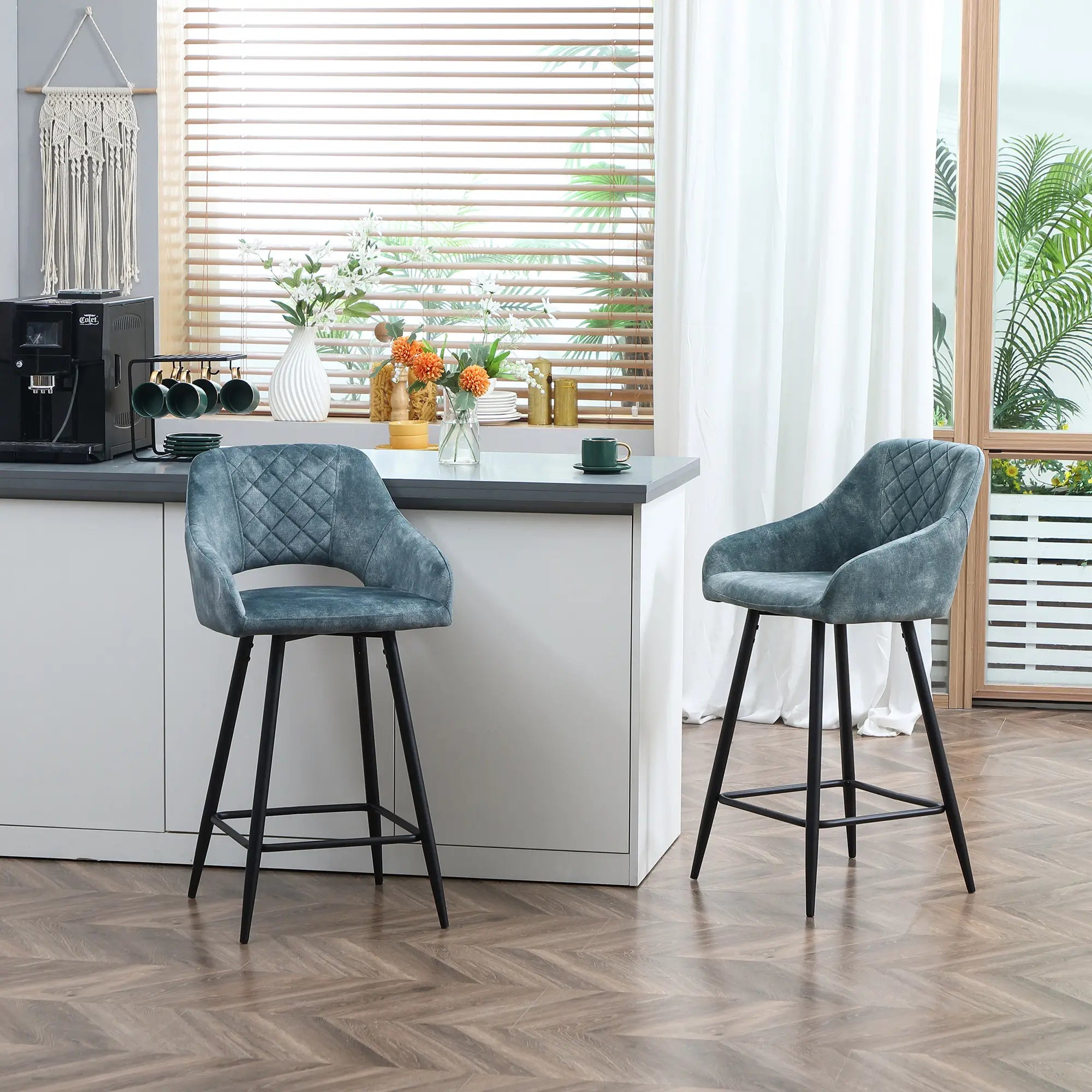 Two blue bar stools in a modern kitchen setting with a window and countertop in the background.