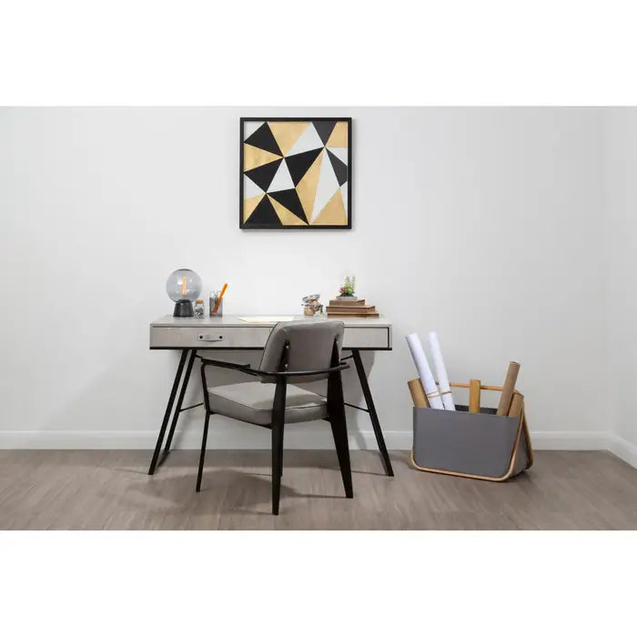 Modern office desk with chair, lamp, and decorative items against a white wall.