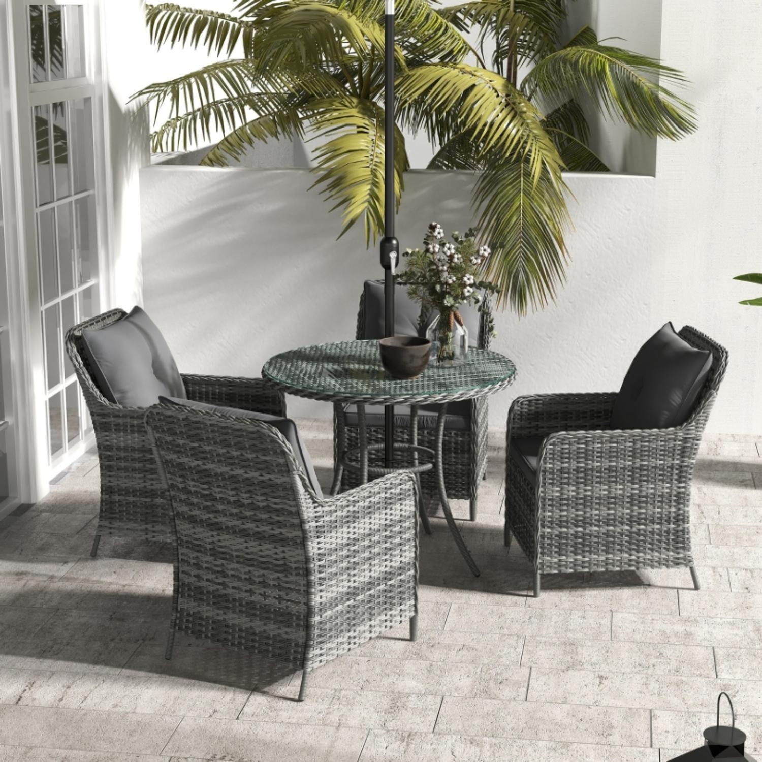 Outdoor patio set with wicker chairs and table on a tiled patio.