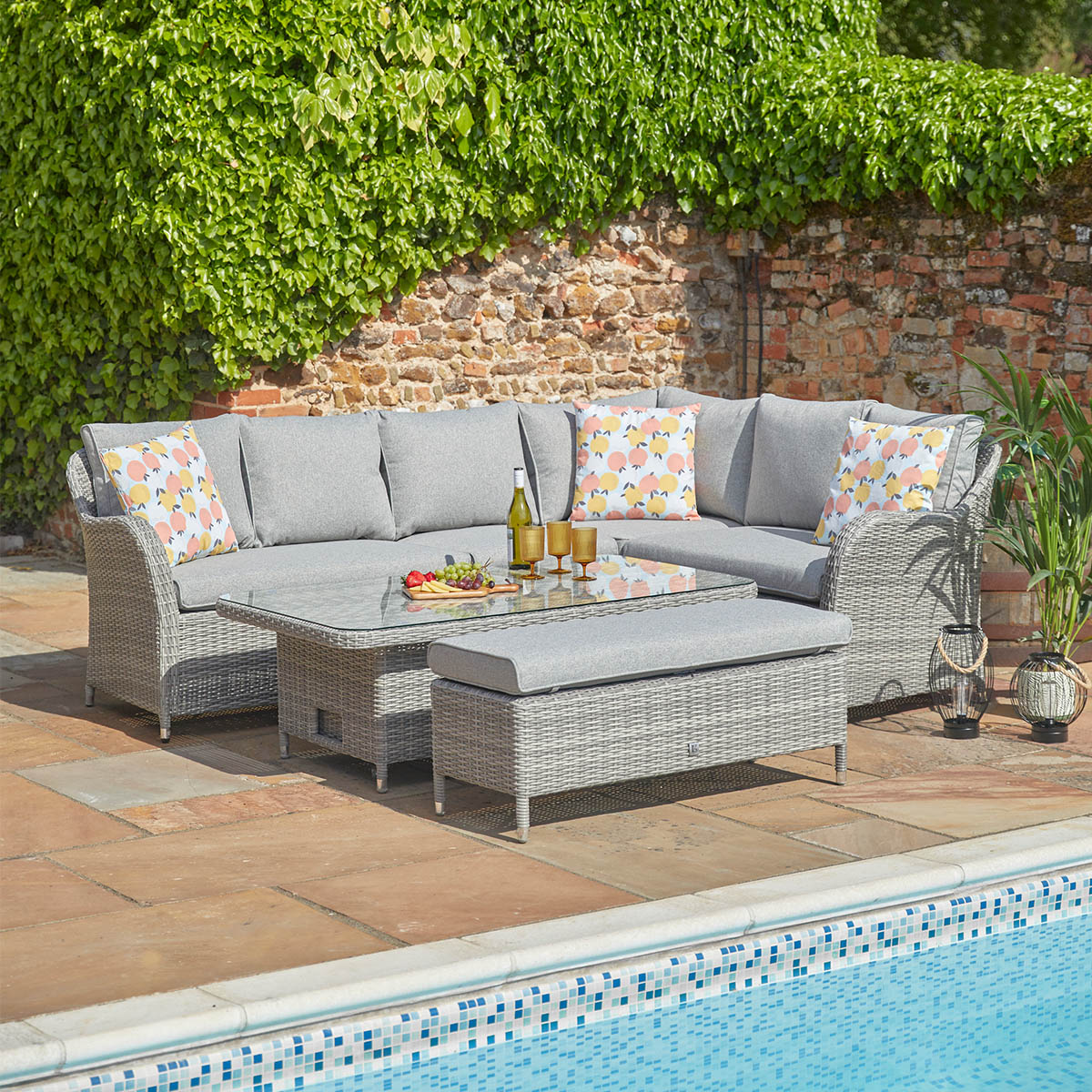Outdoor patio furniture set with a sectional sofa and coffee table by a pool.