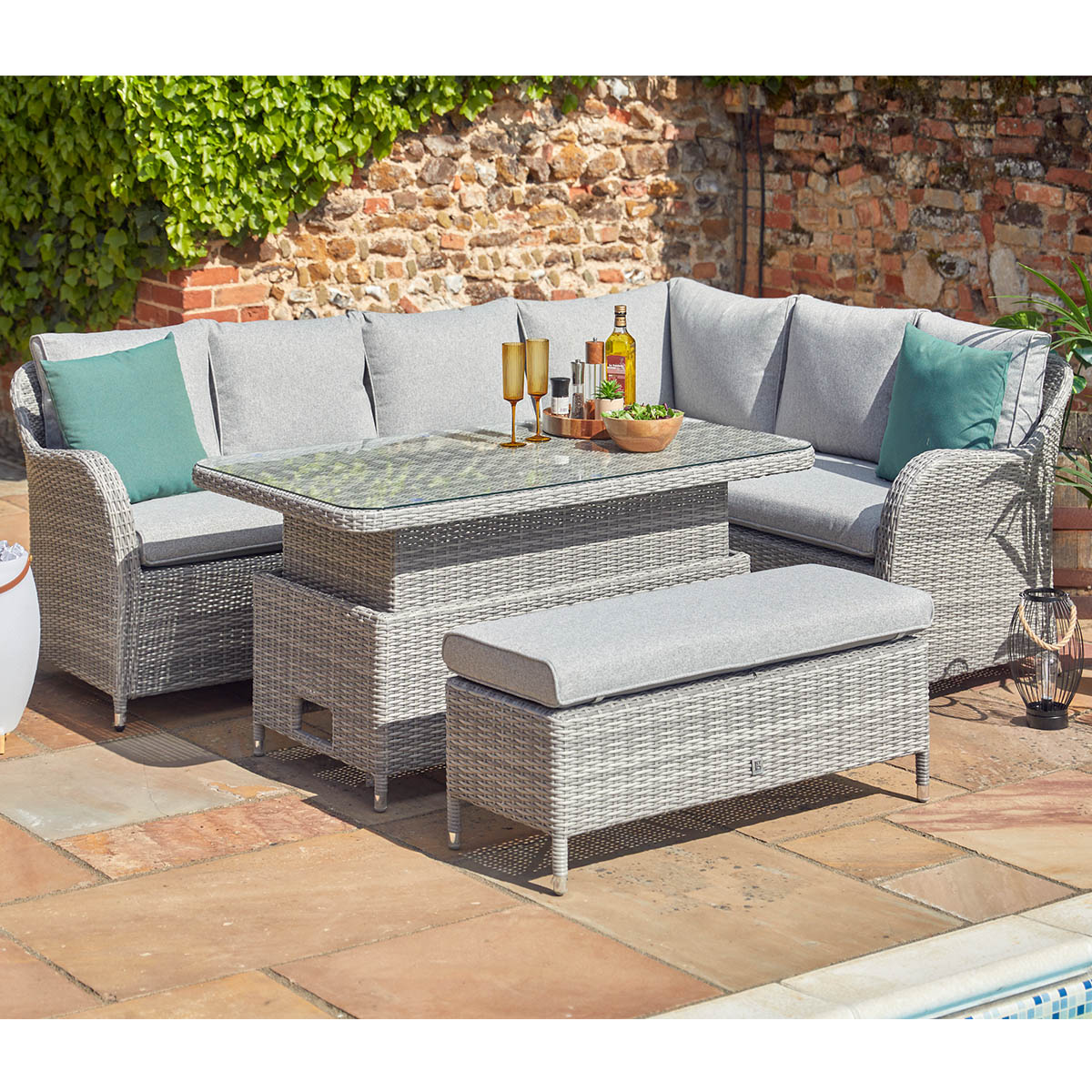Outdoor patio furniture set with cushions on a stone patio.