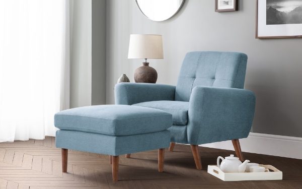 Blue armchair with matching ottoman in a living room setting.