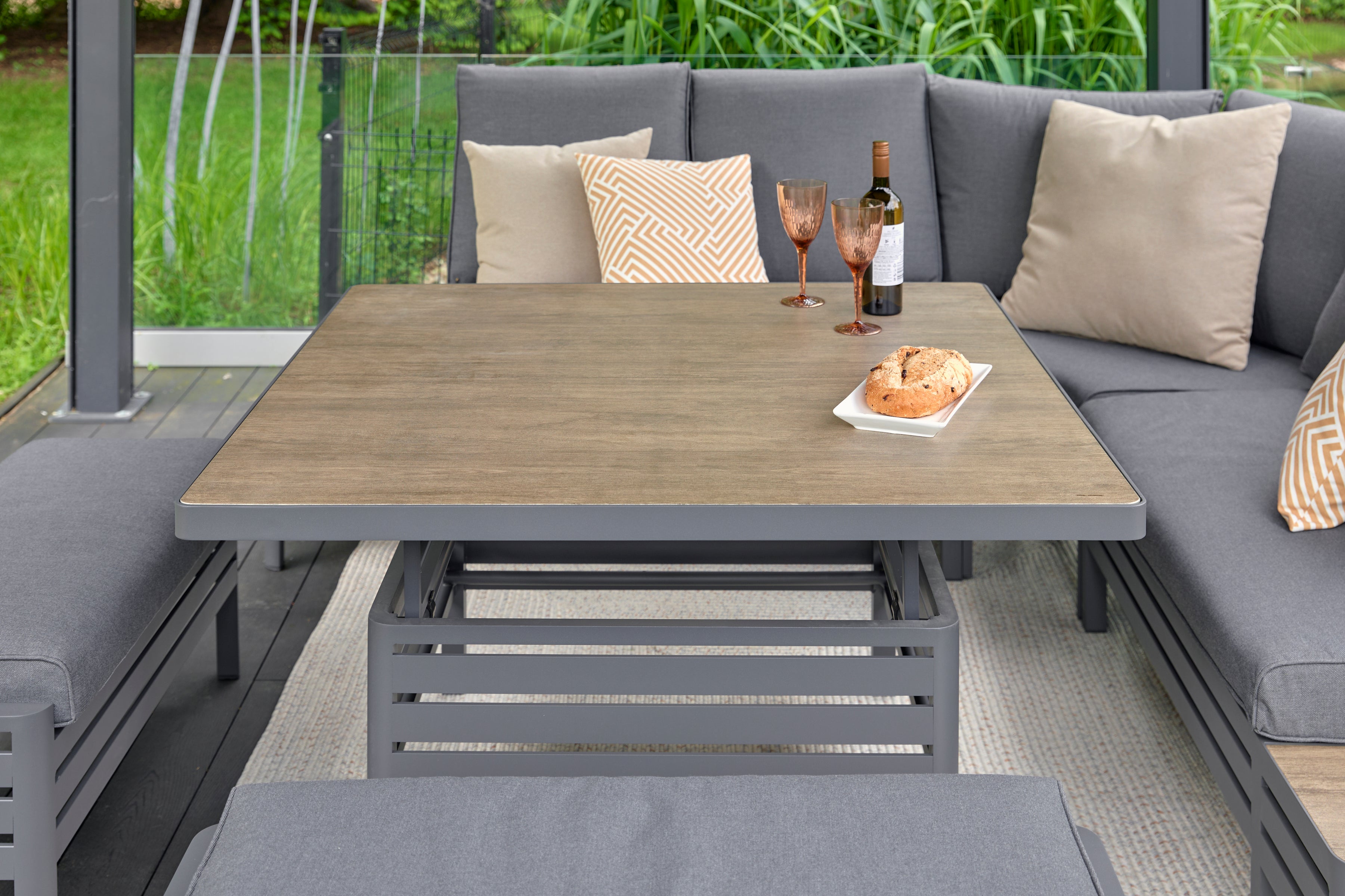 Outdoor patio set with table, chairs, and cushions in a garden setting