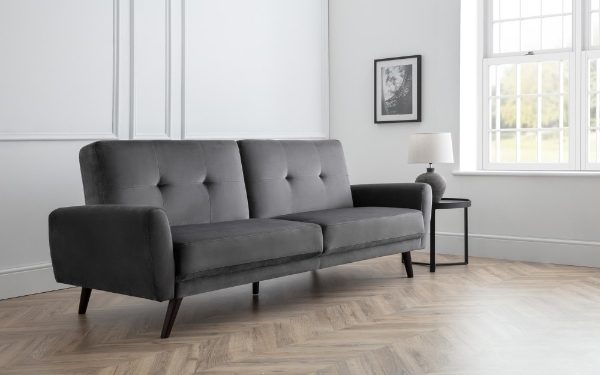 Gray sofa in a living room with wooden flooring and a window in the background