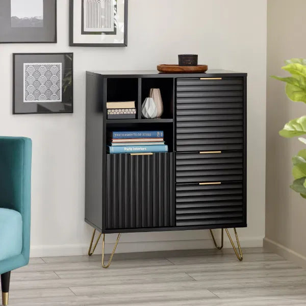 Black cabinet with gold legs in a room with a blue chair and framed pictures on the wall.