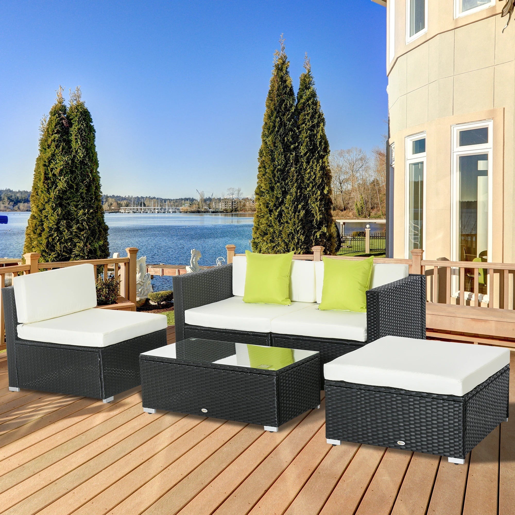 Outdoor patio furniture set on a wooden deck with a view of water and trees.