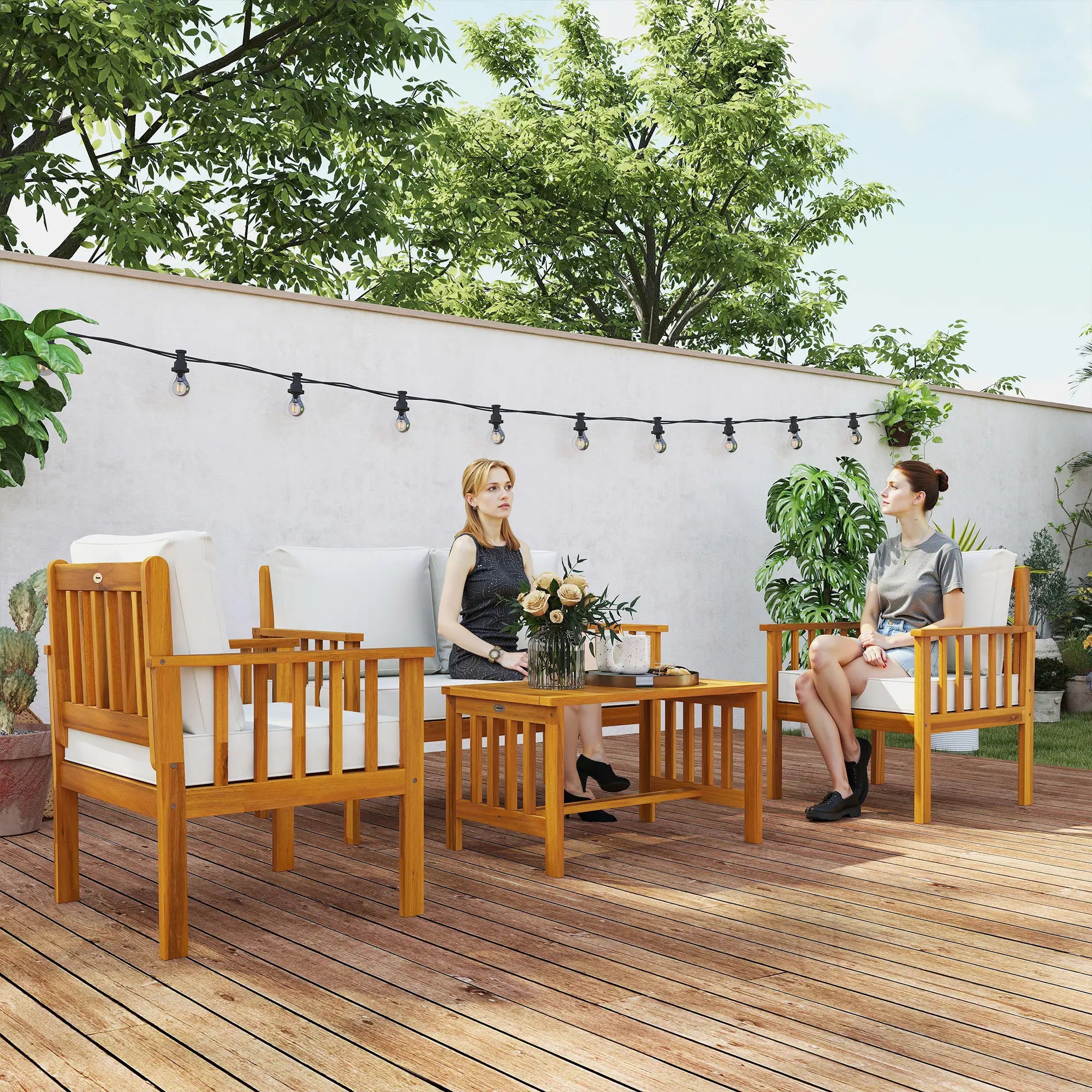 Two women sitting on wooden outdoor furniture with a table and chairs on a deck.