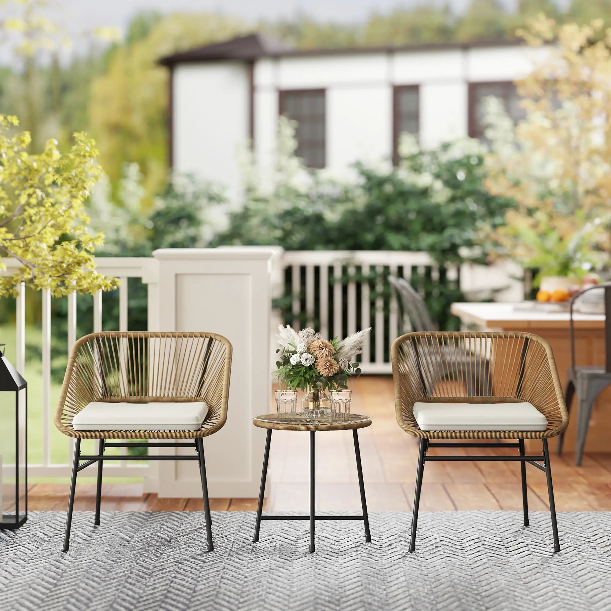 Outdoor patio set with two wicker chairs and a small table on a wooden deck.