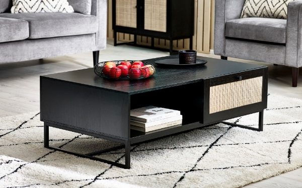 Black coffee table with decorative items in a living room setting