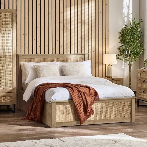 Wooden bed with white bedding and a brown throw blanket in a bedroom setting.