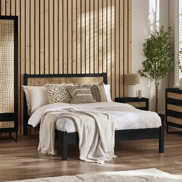 Bedroom with a black bed frame, white bedding, and decorative pillows.