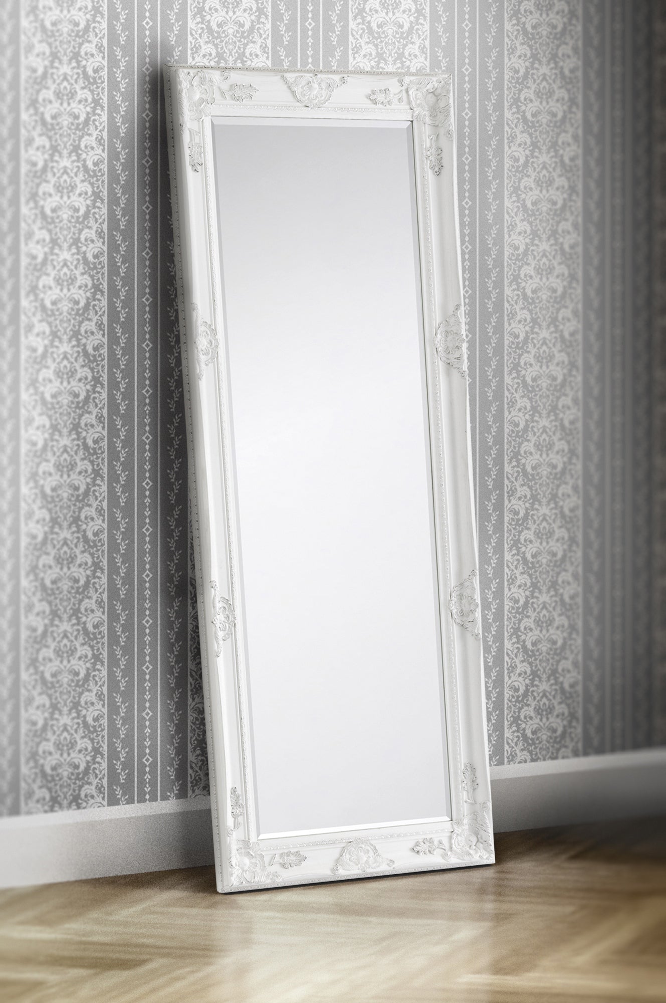 Decorative floor mirror with ornate frame against a patterned wall.