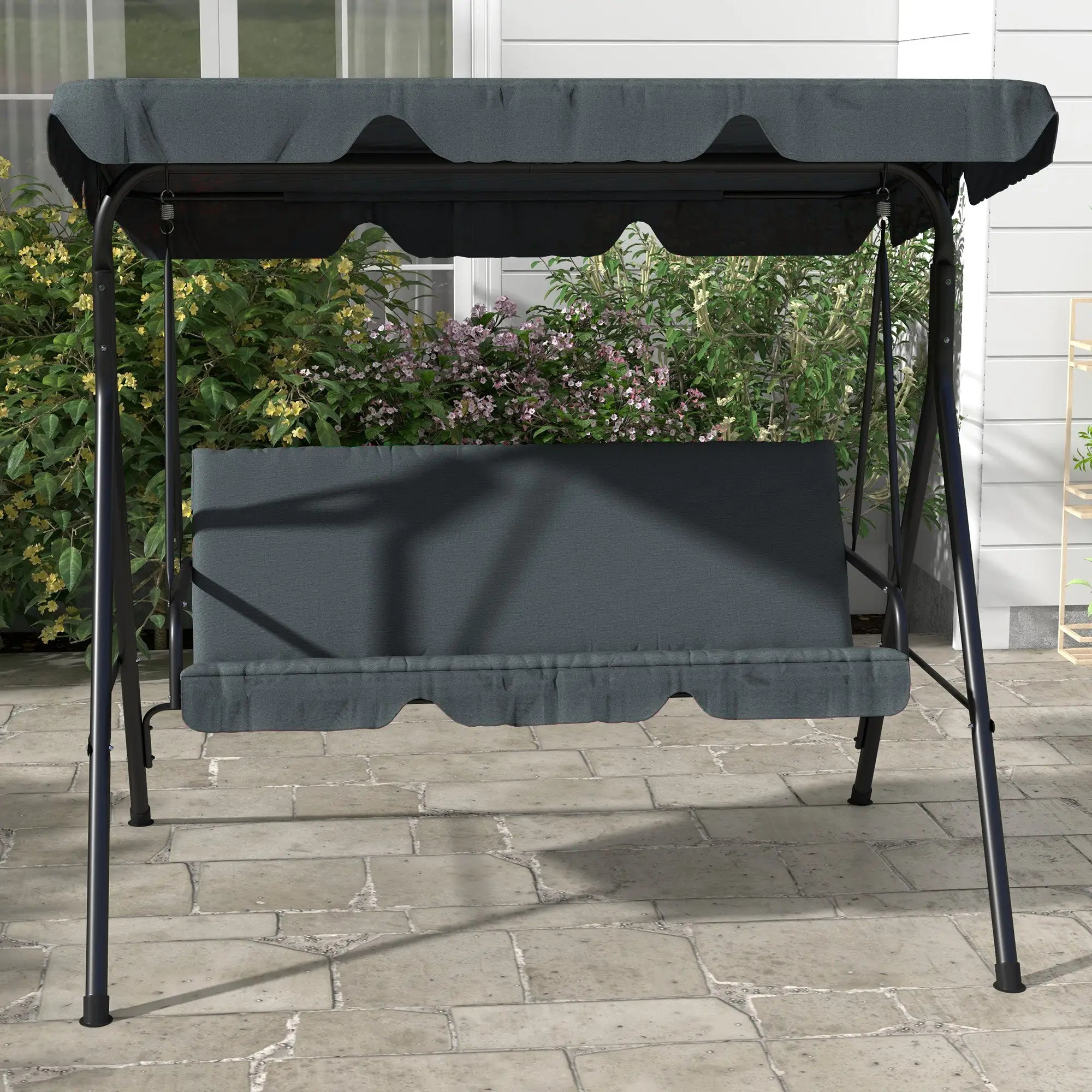 Gray outdoor swing with canopy on a stone patio