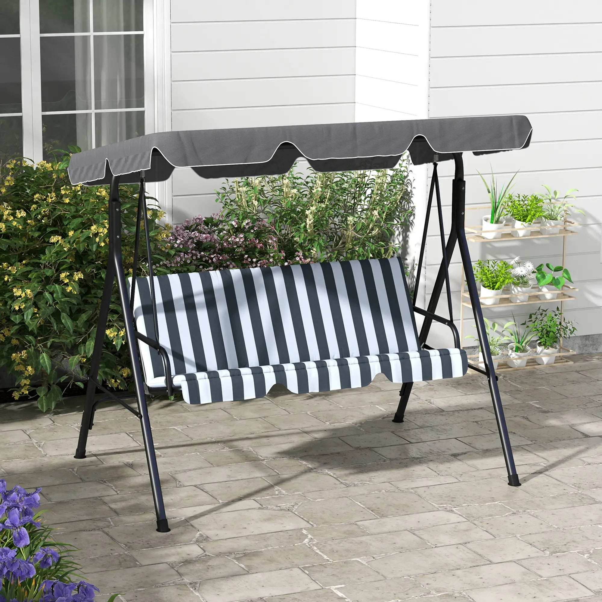 Grey and white striped swing with canopy on a patio
