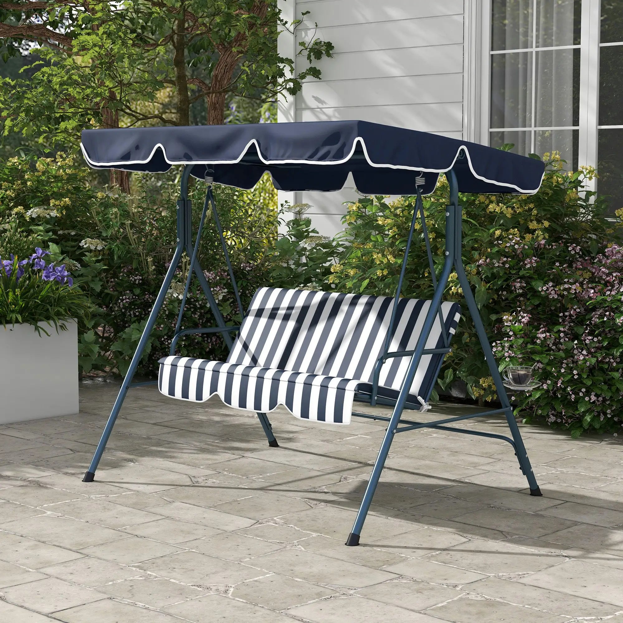 Garden swing with striped cushion and navy canopy on a stone patio