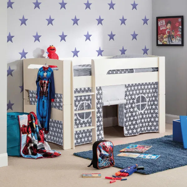 Children's room with a playhouse bed, superhero costumes, and toys on a star-patterned wall.