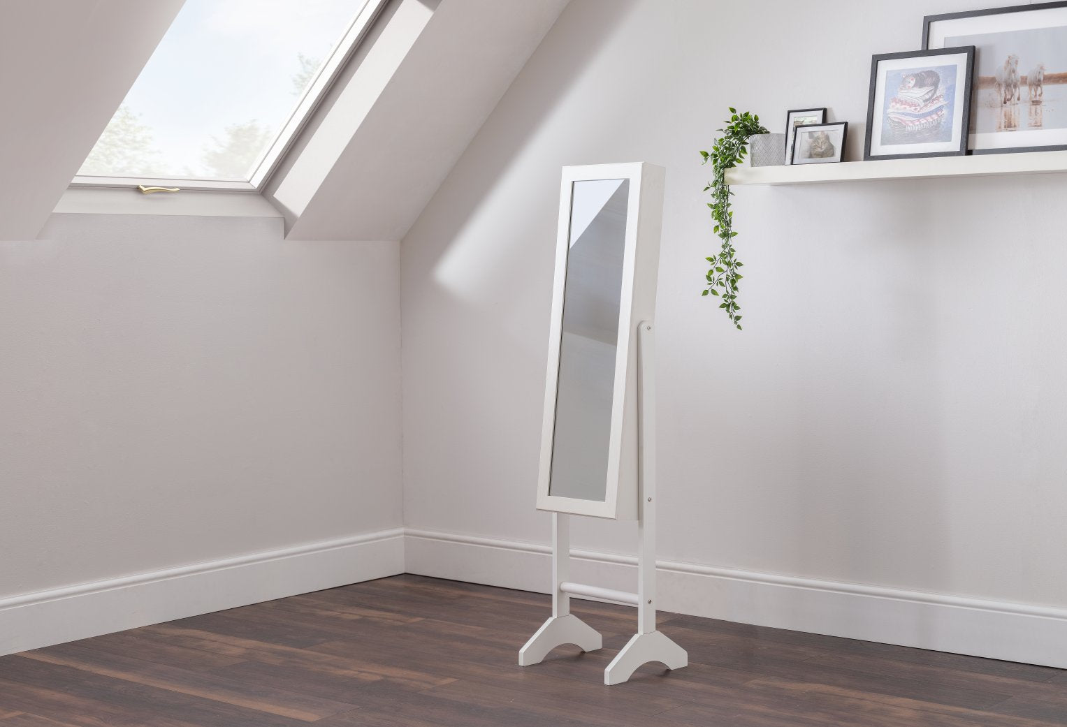 White standing mirror in a room with a skylight and shelves.