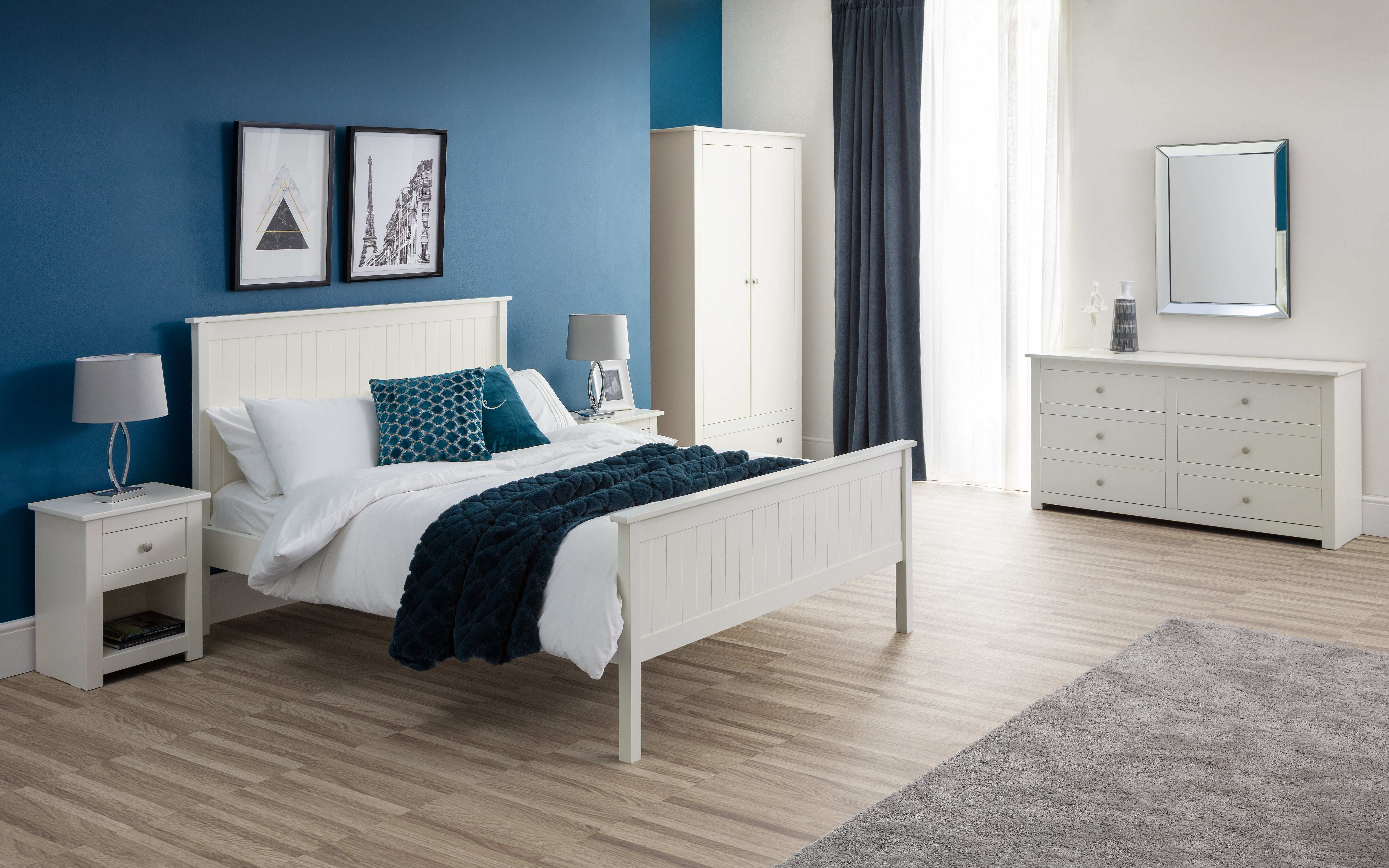 Modern bedroom with white furniture, blue walls, and decorative elements.