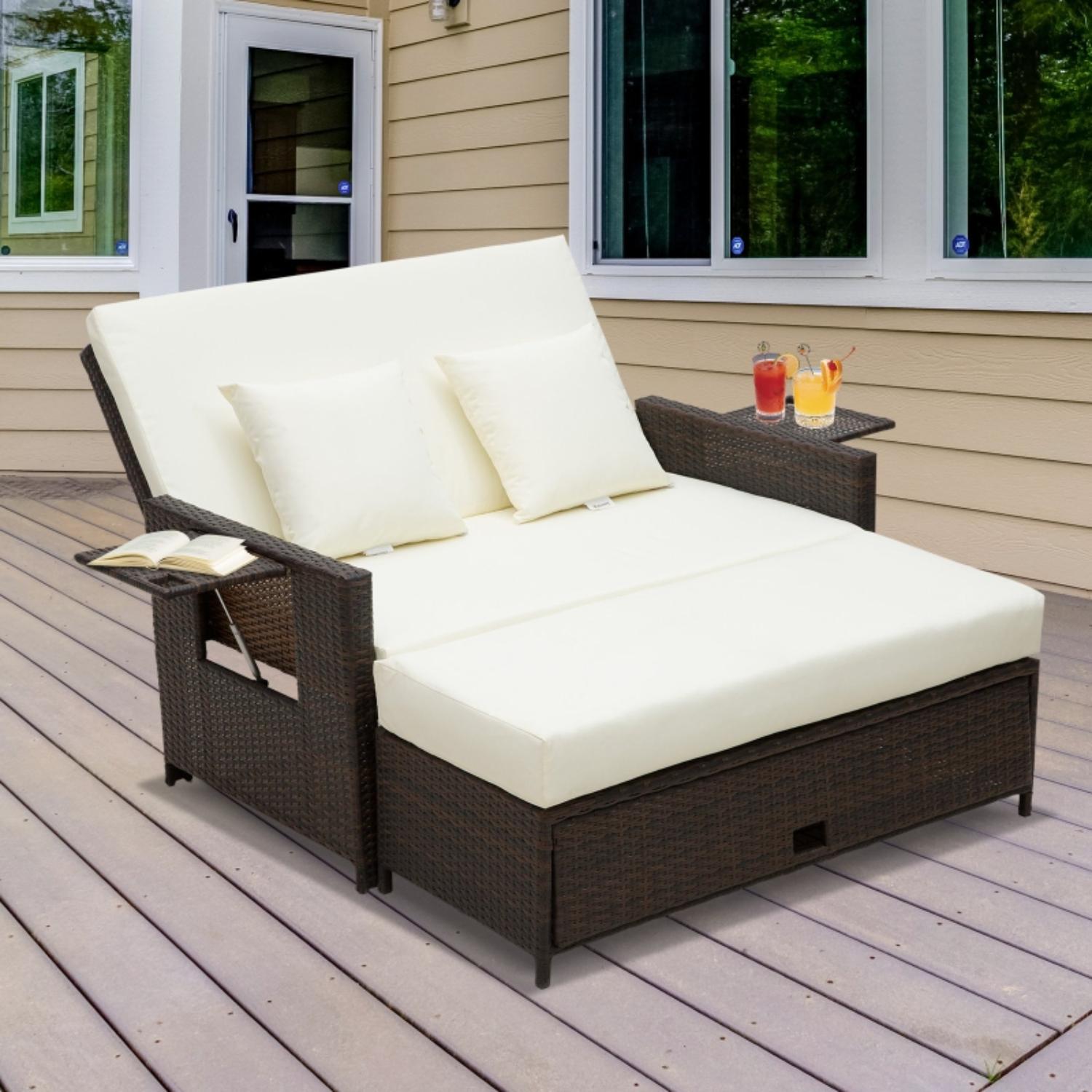 Outdoor patio chair with white cushions on a wooden deck, featuring a small table with drinks.