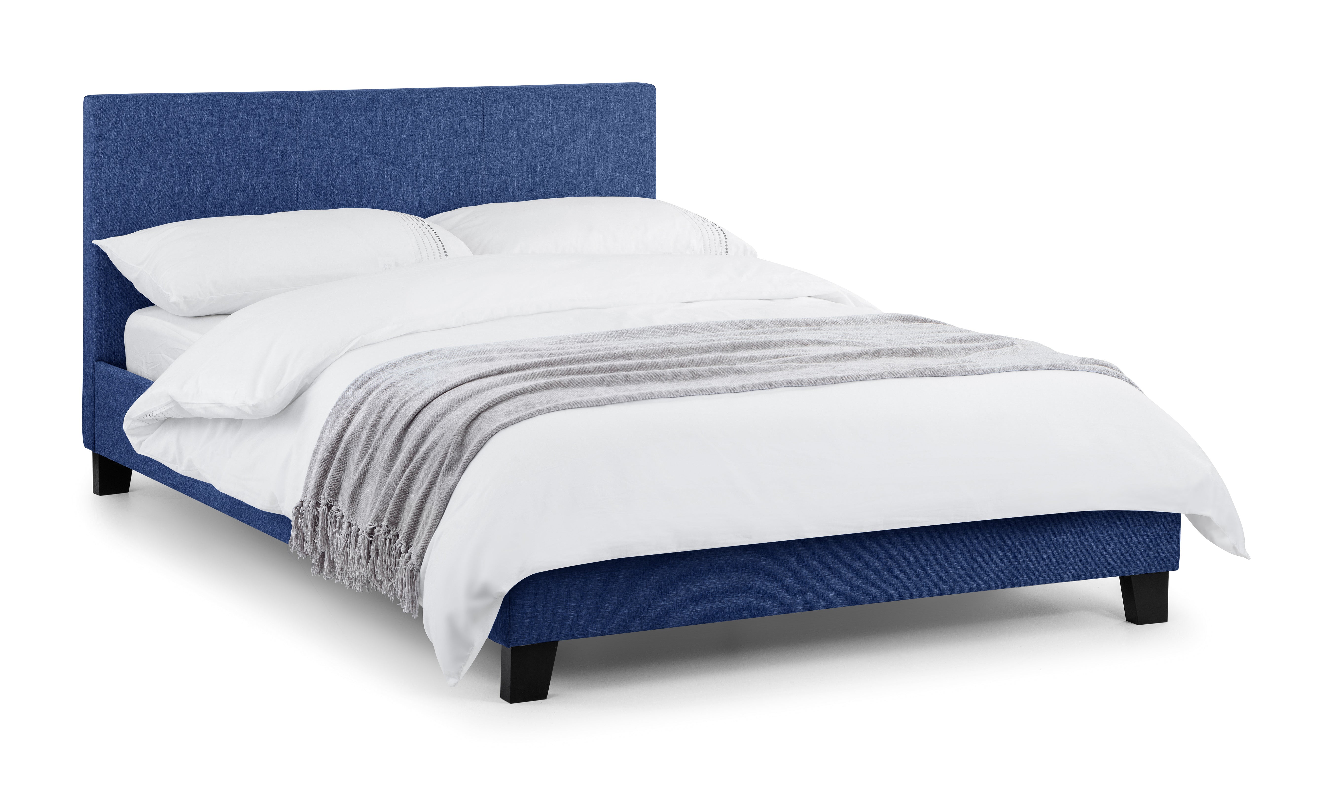 Blue upholstered bed with white bedding on a white background
