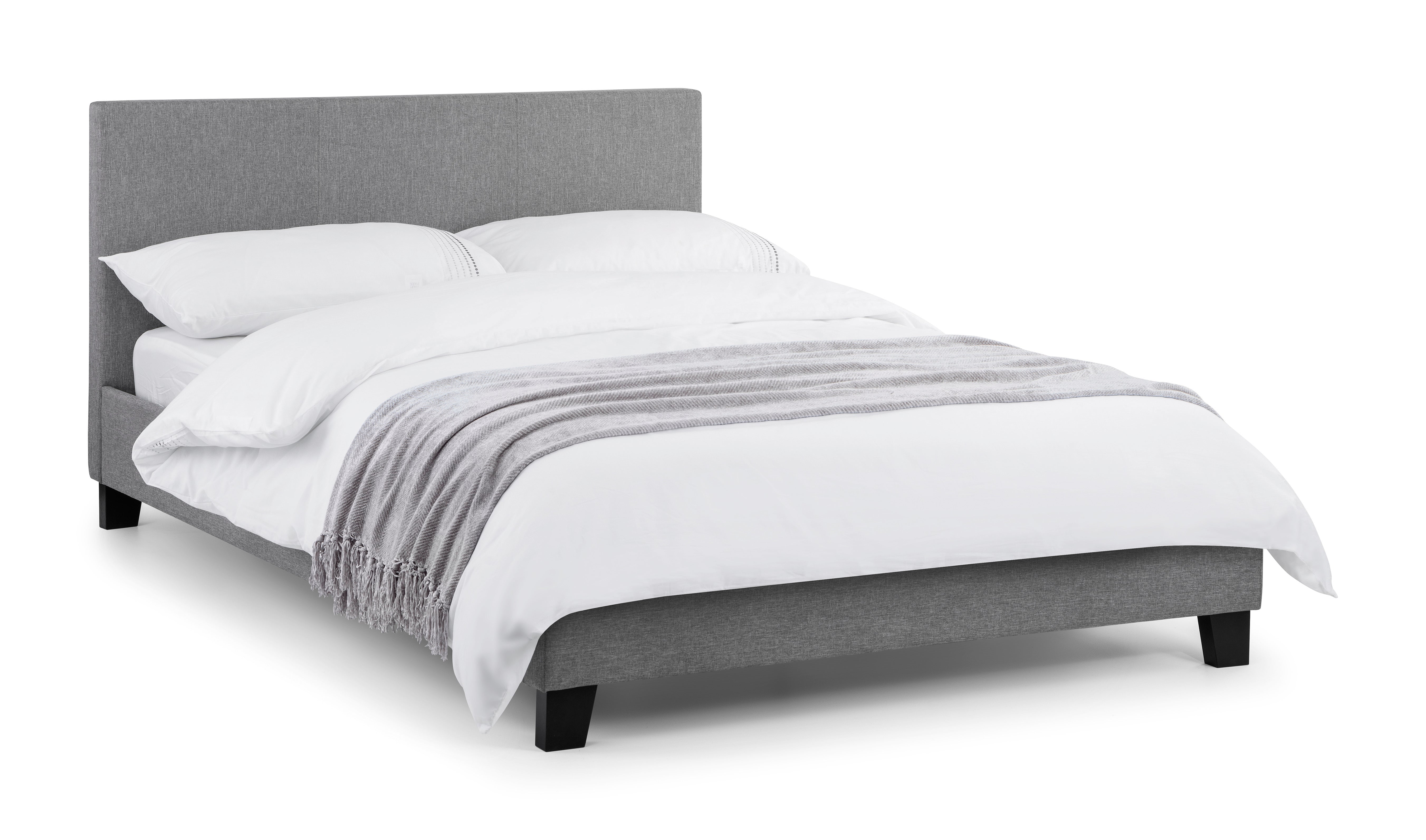 Gray upholstered bed with white bedding on a white background