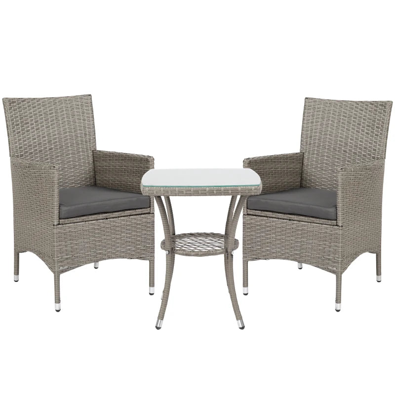 Two wicker chairs with gray cushions and a matching table on a white background