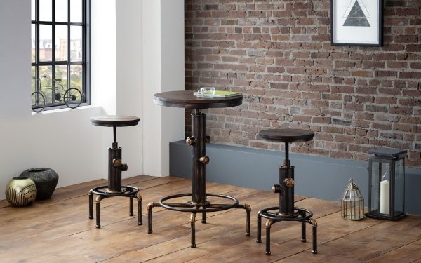Set of three industrial-style stools in a room with brick wall and window.