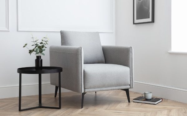 Gray armchair in a modern living room with a side table and plant.