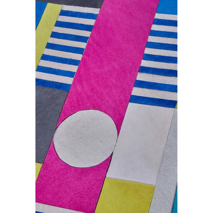 Colorful geometric patterned rug with pink, blue, yellow, and gray shapes.