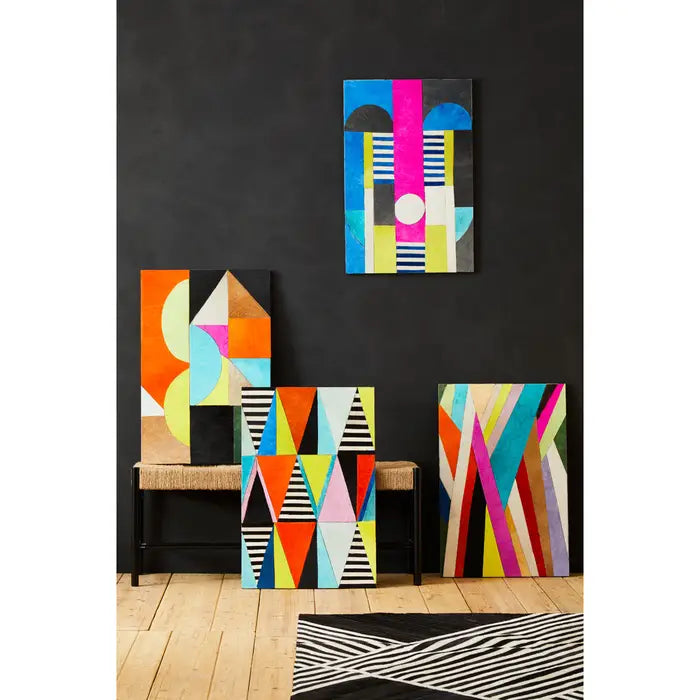 Colorful geometric wall art pieces on a black wall with a wooden bench.