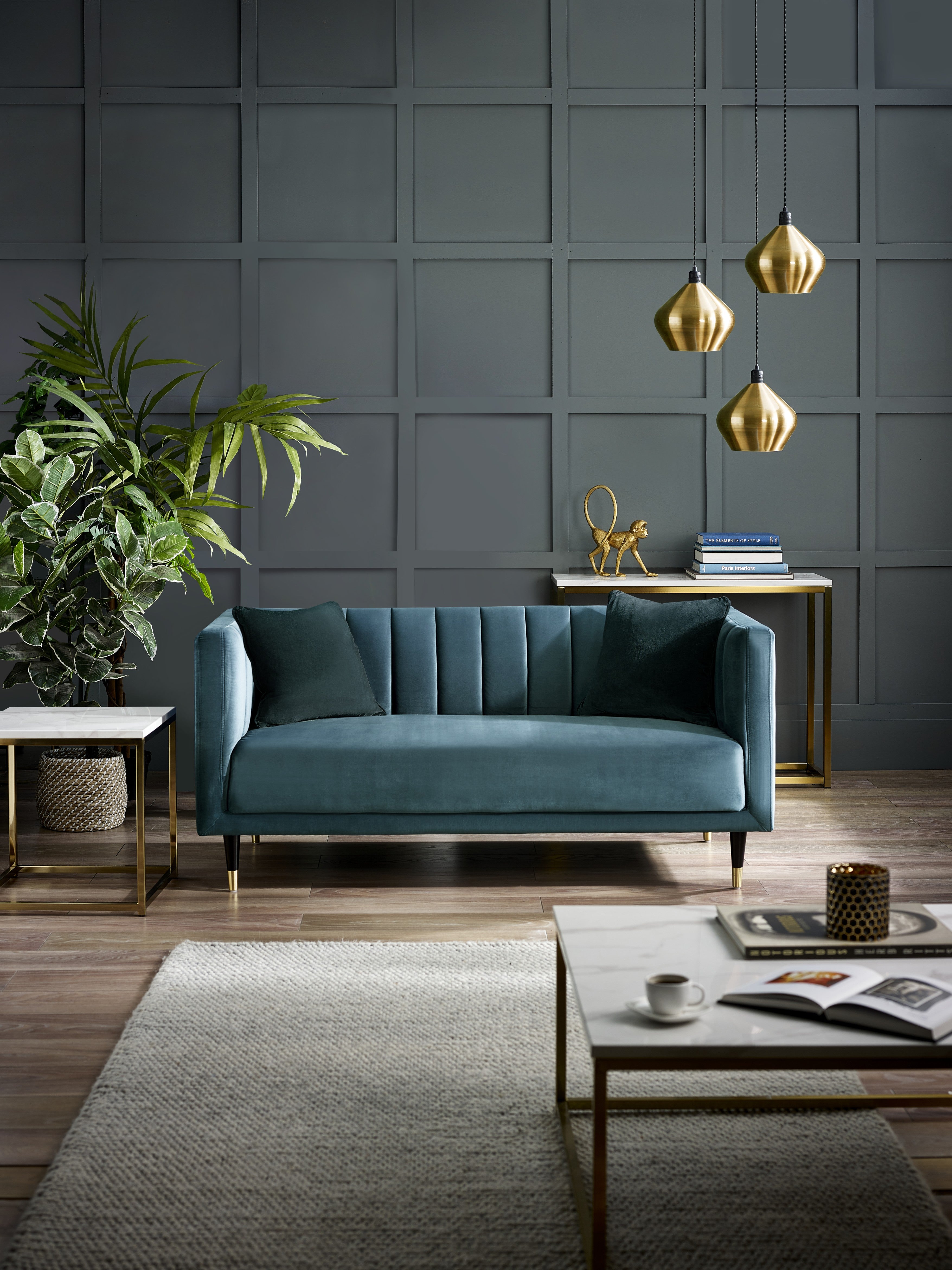 Modern living room with a teal sofa, coffee table, and decorative items.