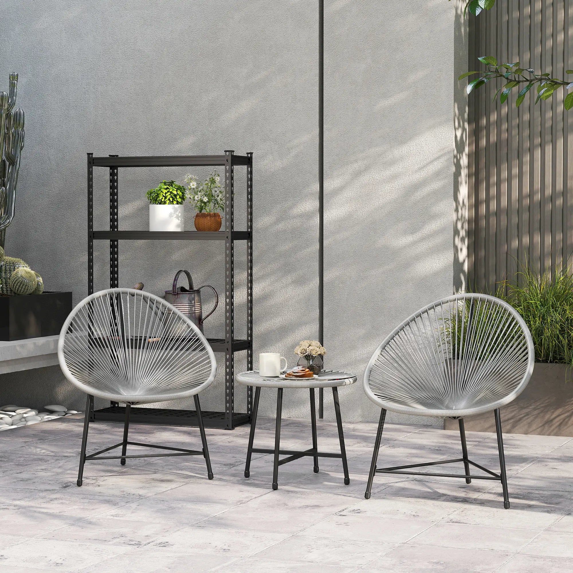 Two modern outdoor chairs with a small table on a patio area.