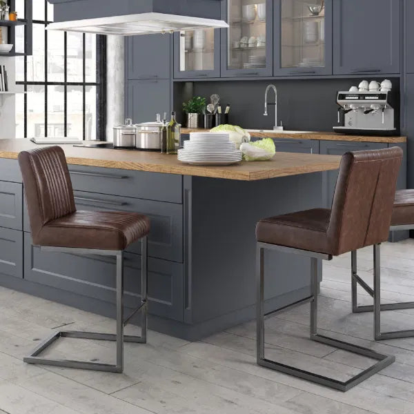 Modern kitchen with gray cabinets, wooden island, and brown bar stools.