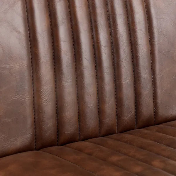 Close-up of brown leather stool with stitching details