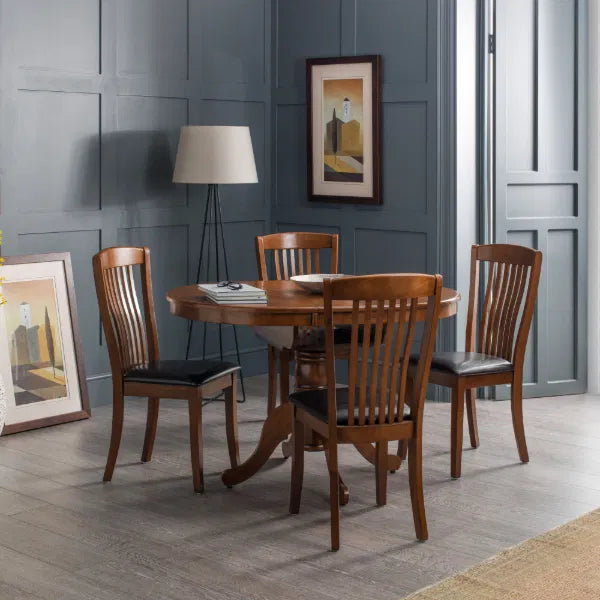 Dining room with wooden table and chairs against a gray paneled wall.
